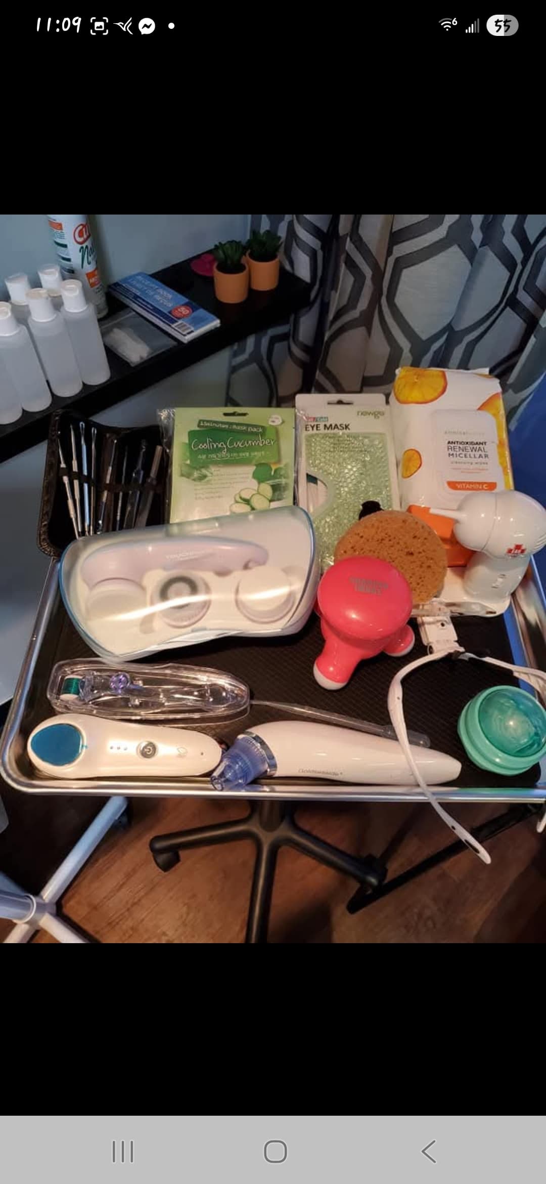 Various skincare tools, facial masks, and electronic beauty devices arranged on a silver metal tray.